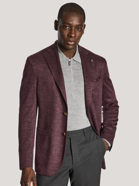 Burgundy melange blazer with notch lapels and gold buttons worn over gray zip-up shirt and charcoal trousers.