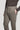 Light brown wool trousers with single pleat front, flat waistband, and side pockets worn with dark sweater.