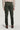 Pine green chino pants with front pleats and button closure, shown from back view on model wearing beige sweater.