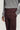 Burgundy chino pants with flat front and button closure, paired with gray ribbed sweater.