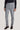 Light gray corduroy tailored trouser with side tabs and belt, shown on model wearing black ribbed sweater.