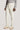 Ecru corduroy tailored trousers with side tabs and belt, featuring pleated front and cuffed ankles.