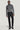 Man wearing charcoal wool turtleneck sweater and black tailored trousers with side tabs.