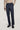 Dark blue wool tailored trousers with pleats and side tabs, worn with beige sweater and black suede shoes.