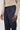Dark blue wool tailored trousers with side tabs and belt detail, styled with a beige sweater.