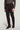 Brown tailored trousers with side tabs and front pleats, paired with a gray long-sleeve sweater.