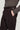 Brown tailored trouser with buckled side tab adjustment at waist and front pocket detail.