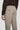 Taupe solid stretch trouser with flat front, back pocket detail, and button closure on wearer.