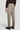 Taupe solid stretch trousers with flat front, button closure, and straight leg on model wearing black shoes.