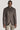 Brown sport jacket with button front, chest pocket, and notch collar worn with beige trousers.