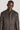 Brown sport jacket with zip collar and button front, worn by model against neutral background.