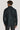 Man wearing dark hunter green shirt jacket with collar and long sleeves, shown from back view.