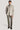 Sand-colored shirt jacket with chest pockets and button front, worn over gray turtleneck and matching trousers.