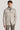 Beige shirt jacket with chest pockets and button front, worn over gray turtleneck.