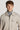 Beige button-front shirt jacket with chest pockets, worn over a gray turtleneck.