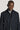 Navy twill topcoat with notch lapels, button front, and gray turtleneck collar insert visible underneath.