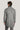 Man wearing black and white herringbone topcoat with black collar, shown from back view.