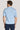 Man wearing light blue polo shirt with collar and short sleeves, shown from back view.