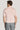 Man wearing pink short-sleeve polo shirt with gray trousers, shown from back view.