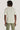 Ecru crew neck short-sleeve t-shirt worn with sage green pants, back view.