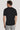Man wearing black short-sleeve crew neck t-shirt, shown from back view.