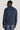 Man wearing a washed navy quarter-zip sweater with ribbed collar and cuffs, shown from behind.