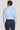 Light blue dress shirt with long sleeves and collar, shown on model from behind wearing navy trousers.
