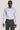 Lilac long-sleeve dress shirt with pointed collar and white button front, worn with charcoal trousers.