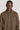 Brown long-sleeve polo shirt with collar and button placket on model.