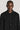 Black long sleeve button-down sweater with ribbed knit texture and collar, worn by a man against a neutral background.