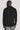 Black long sleeve button down sweater with ribbed collar and cuffs, shown from back view on model.