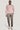 Pink crewneck sweatshirt with long sleeves and ribbed cuffs, styled with gray trousers and cream sneakers.