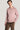Pink crewneck sweatshirt with ribbed trim worn by man with brown pants.