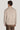 Man wearing sand-colored crewneck sweatshirt with ribbed cuffs and hem, shown from back view.