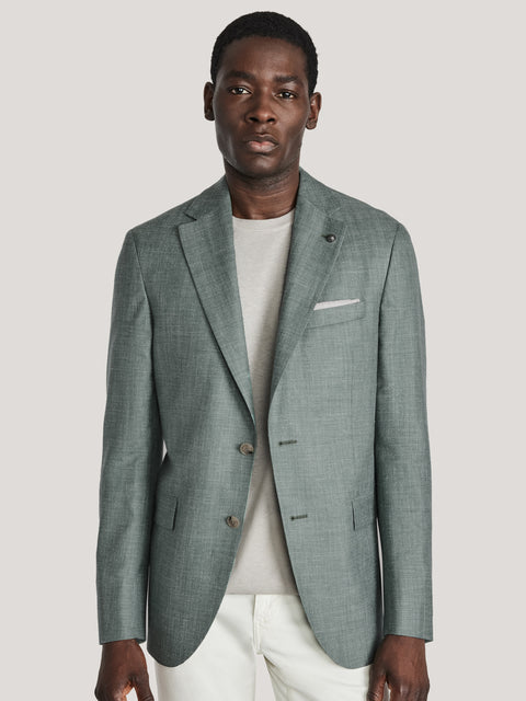 Sage green melange blazer with notch lapels, button front, and chest pocket worn over white shirt and pants.