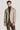 Light tan herringbone blazer with notch lapels and button front, worn over dark turtleneck.