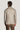 Man wearing light tan herringbone blazer with ribbed collar, shown from back view.