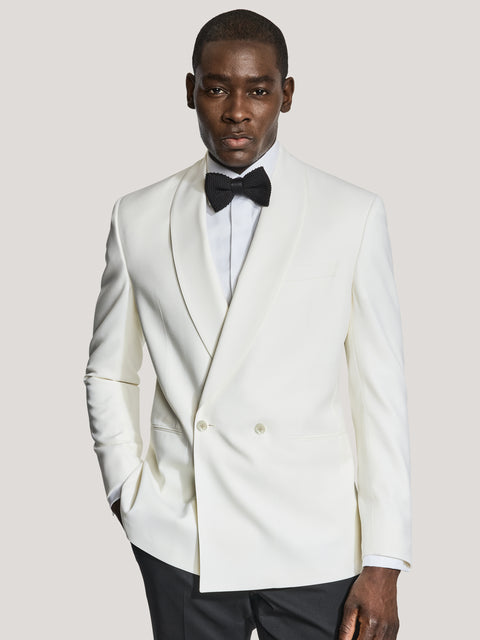Cream double breasted dinner jacket with peaked lapels worn with black bow tie and black trousers.