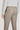Sand-colored single pleat trouser with flat front waistband, button closure, and welt pockets shown from rear view.