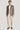 Man wearing brown melange blazer with white dress shirt and cream trousers, styled with brown suede shoes.