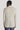 Cream solid blazer with long sleeves and button cuffs, shown from back view on model wearing jeans.