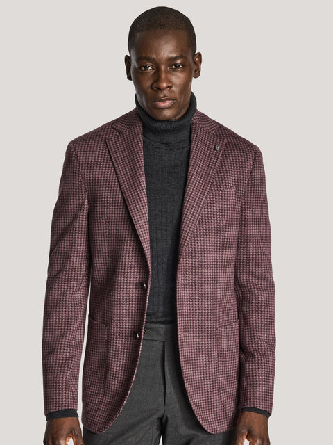 Berry houndstooth blazer with notch lapels worn over charcoal turtleneck and gray trousers.