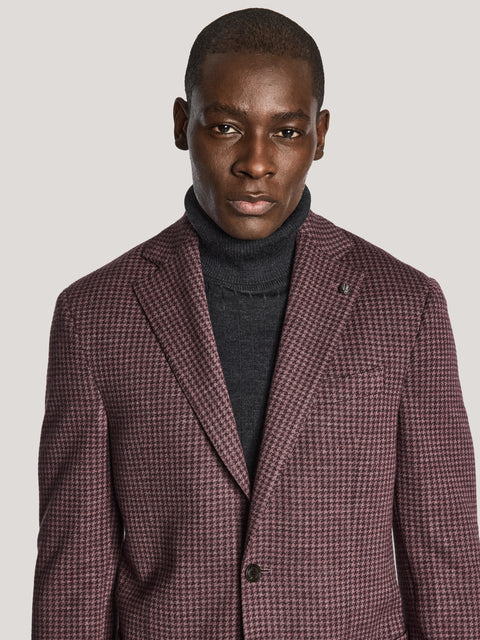 Berry and charcoal houndstooth blazer with notch lapels worn over black turtleneck.